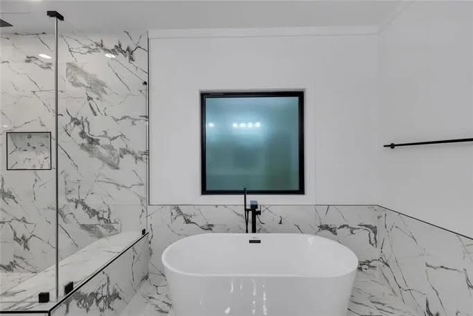 Freestanding tub in a marble bathroom
